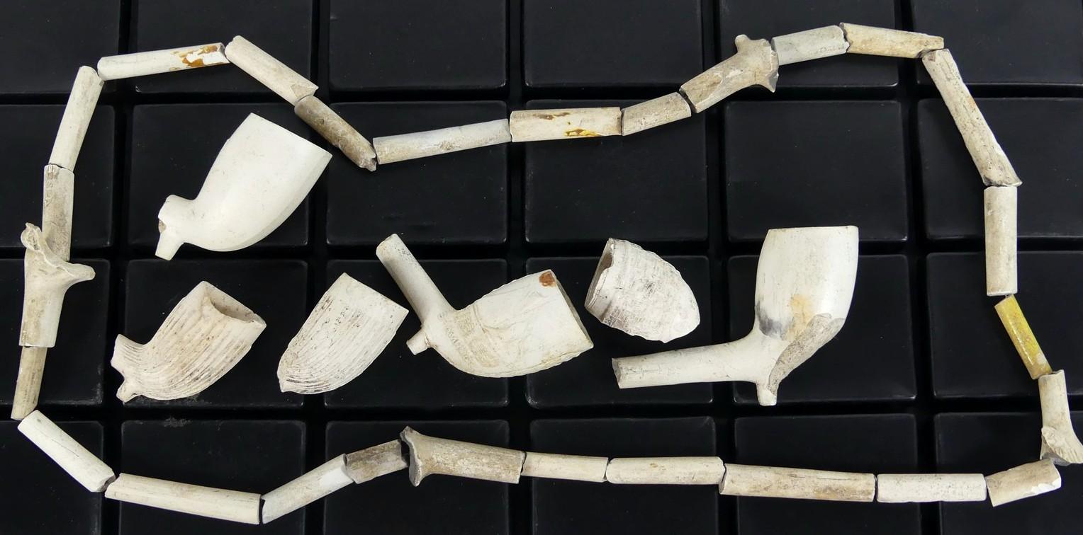 COLLECTION OF CLAY PIPE BOWLS AND STEMS