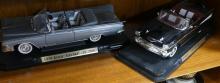 FOUR DIE-CAST CAR MODELS ON DISPLAY STANDS