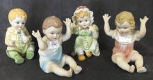 FOUR "PIANO BABY" FIGURINES